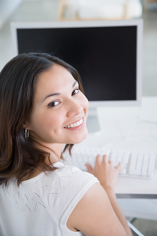 Smiling young woman at computer