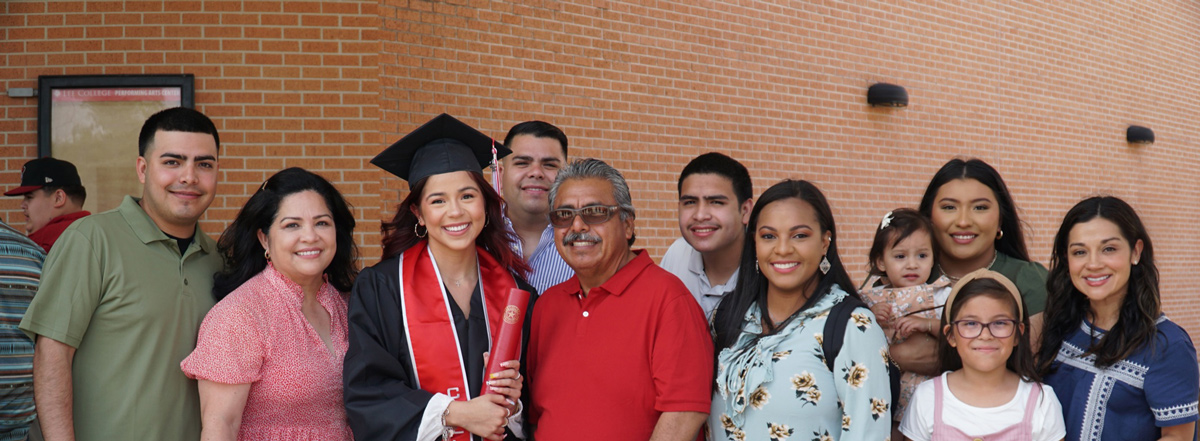 A large family poses with a Lee College student on her graduation day.