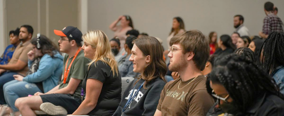 Rows of seated students listen to a presentation