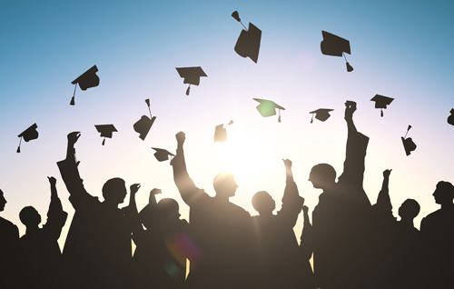 Silhouettes of graudates tossing their caps