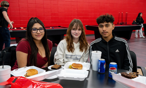 IMPACT Early College High School students (l-r) Diamond Rodriguez, Eris Hawkins and Jefferson Rodriguez enjoy a meal in the Game Room during the grand re-opening celebration for the renovated Student Center.