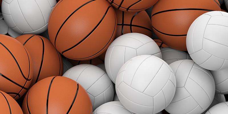 A pile of basketballs and volleyballs