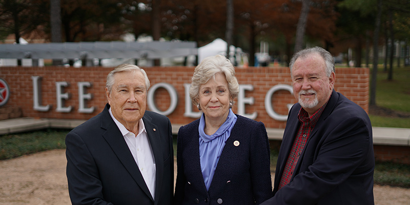 Three donors pose with a donation check