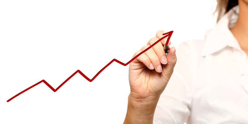 A woman drawing a line graph trending upward