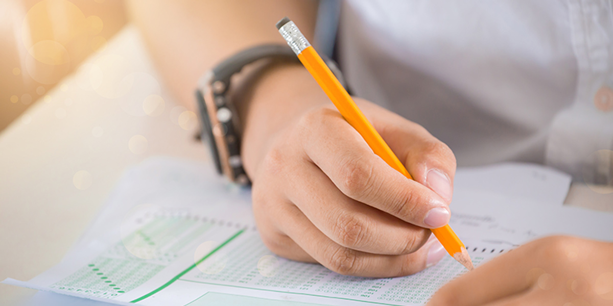 A hand writing on an exam sheet