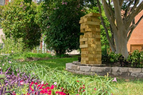 A Jenga-style display under a tree