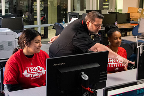 A man points to something on a computer screen