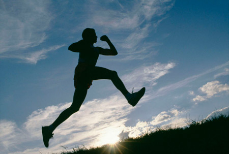 Male runner in silhouette leaping